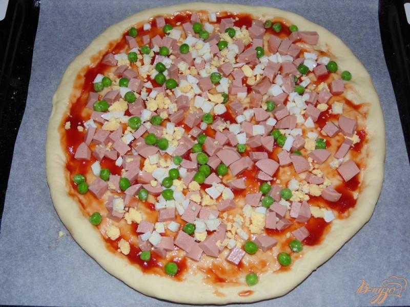 Фото приготовление рецепта: Пицца с сосисками, яйцом и зеленым горошком шаг №7