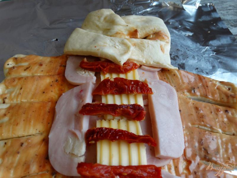 Фото приготовление рецепта: Стромболи с ветчиной сыром и вылеными помидорами шаг №7