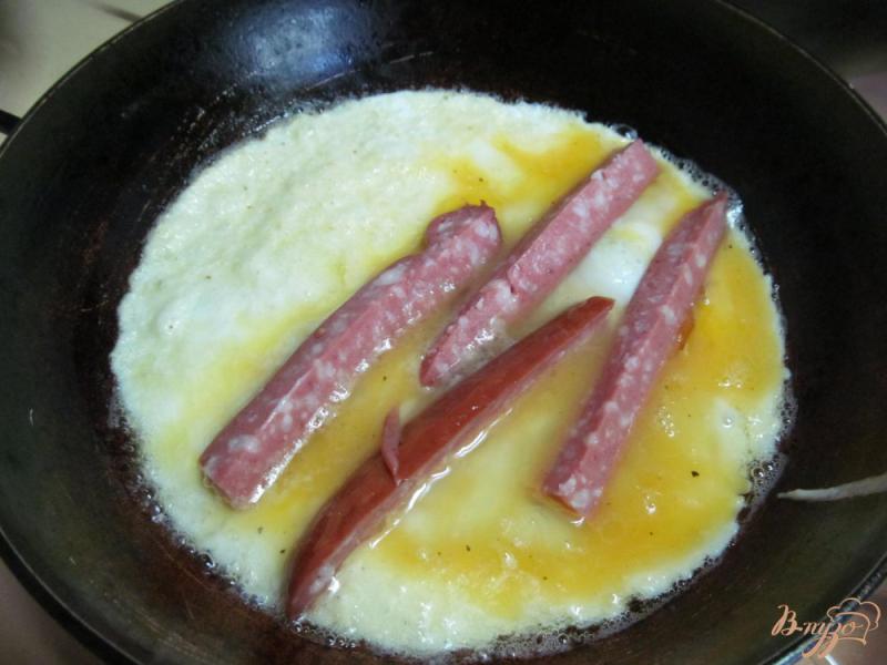 Фото приготовление рецепта: Яйца с колбасой под помидором шаг №6