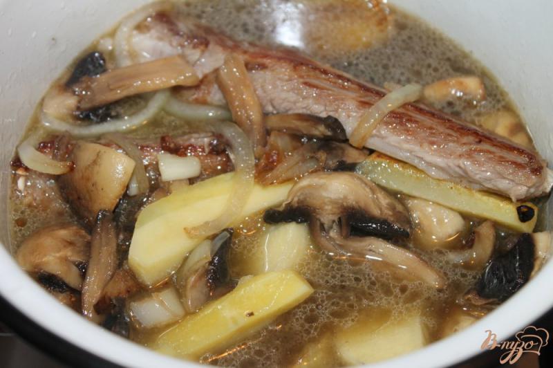 Фото приготовление рецепта: Тушенный картофель с грибами и свиными ребрами шаг №6