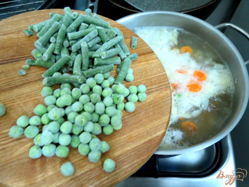 Фото приготовление рецепта: Суп с кусочками лосося, зелёным горошком и спаржевой фасолью шаг №4