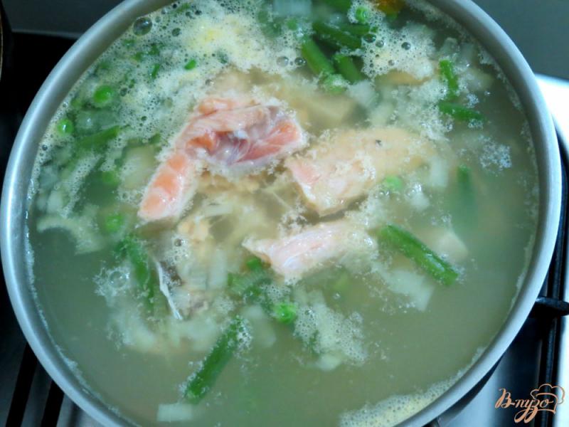 Фото приготовление рецепта: Суп с кусочками лосося, зелёным горошком и спаржевой фасолью шаг №5