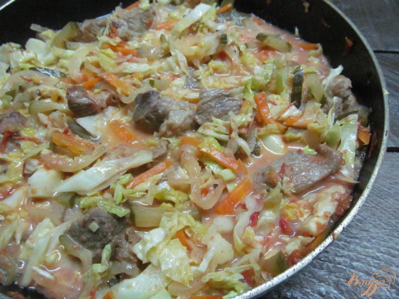 Фото приготовление рецепта: Тушенное мясо с капустой и маринованным огурцом шаг №7
