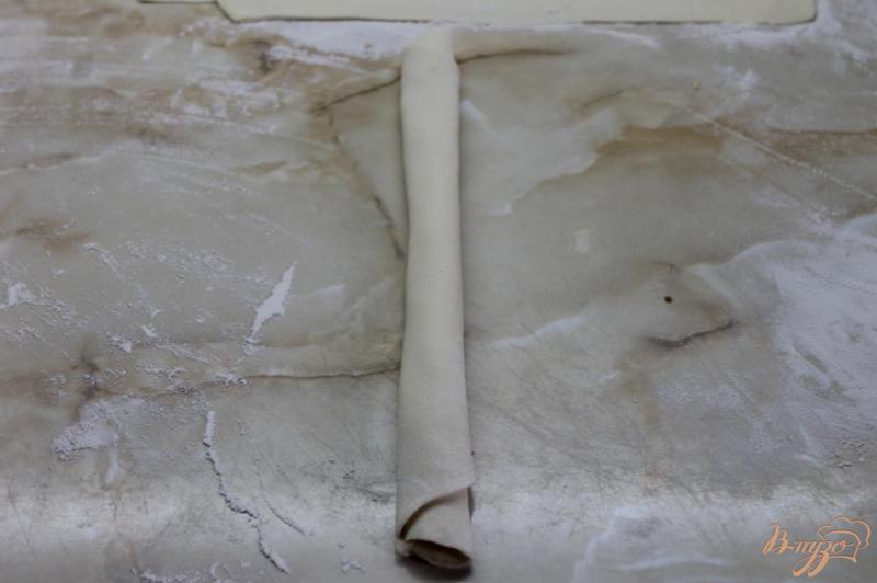 Фото приготовление рецепта: Улитки из слоеного теста с твердым сыром и кунжутом шаг №5