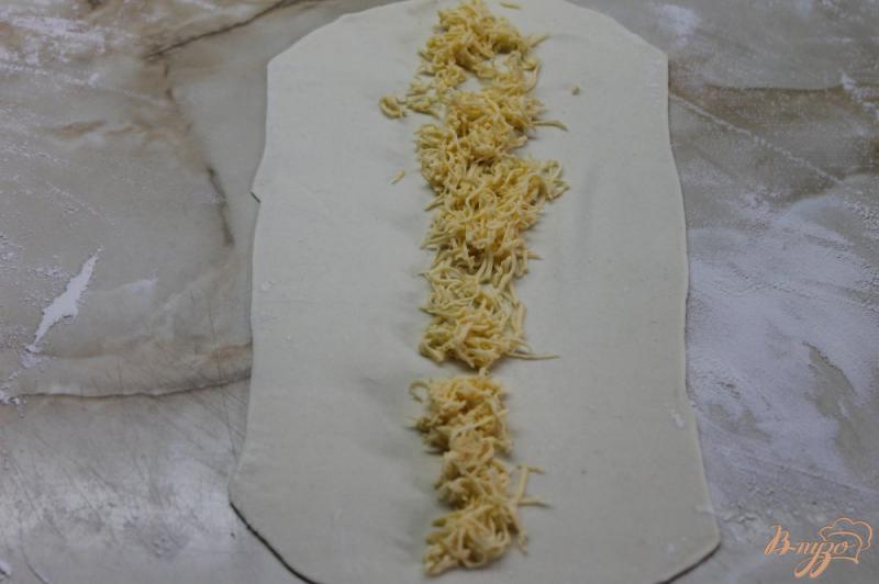 Фото приготовление рецепта: Улитки из слоеного теста с твердым сыром и кунжутом шаг №4
