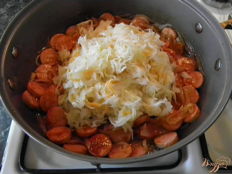 Фото приготовление рецепта: Тушенная квашеная капуста с сосисками шаг №5