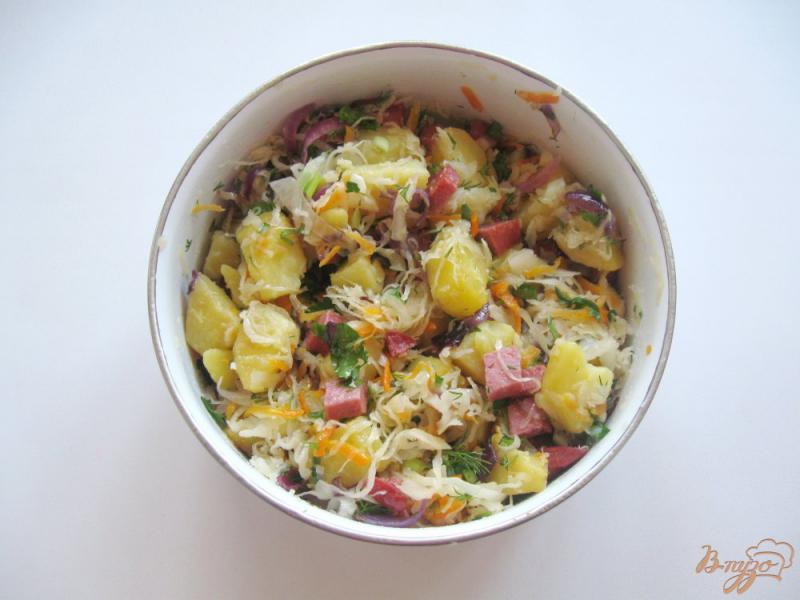 Фото приготовление рецепта: Теплый салат с квашеной капустой и копченой колбасой шаг №8