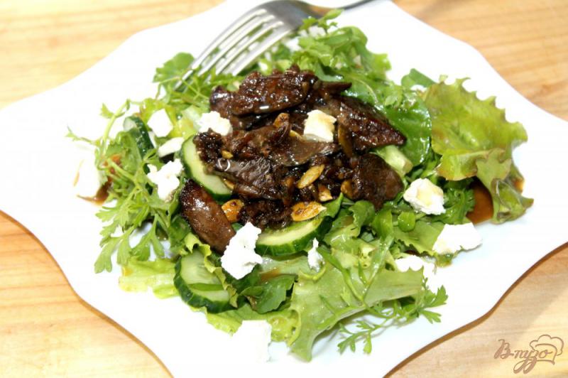 Фото приготовление рецепта: Теплый салат из куриной печени с тыквенными семечками и апельсиновым соусом шаг №9