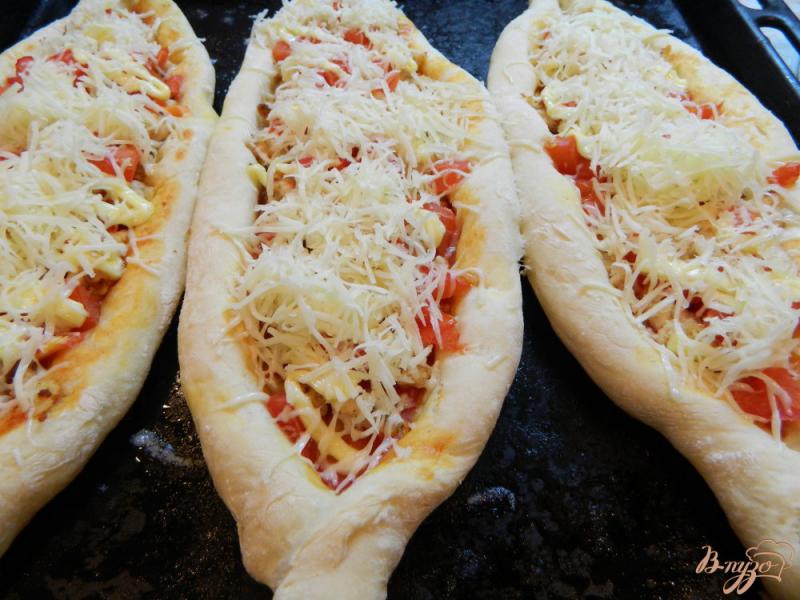 Фото приготовление рецепта: Пицца в виде лодочки с куриным фаршем, помидором и сыром шаг №12