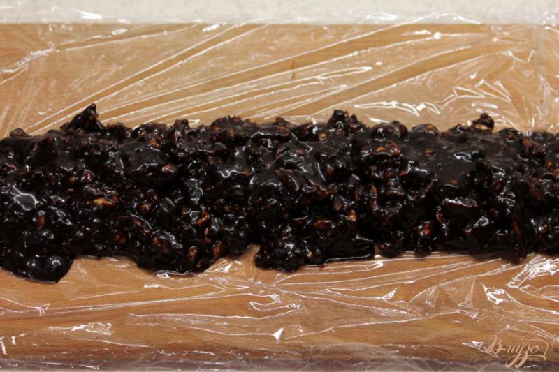 Фото приготовление рецепта: Сладкая колбаса из галетного печенья и шоколадной глазури, с орехами и пряностями шаг №6