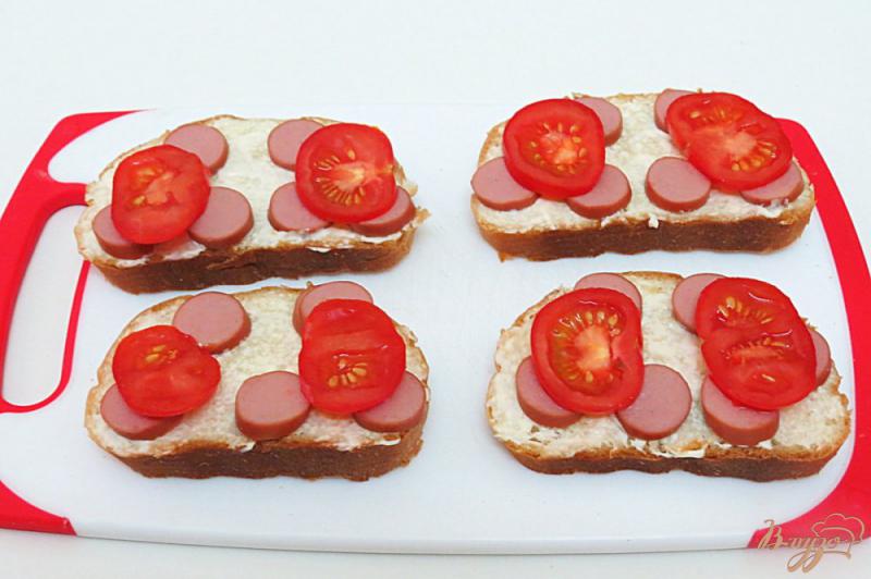 Фото приготовление рецепта: Горячие бутерброды с сосиской помидором и огурцом шаг №4