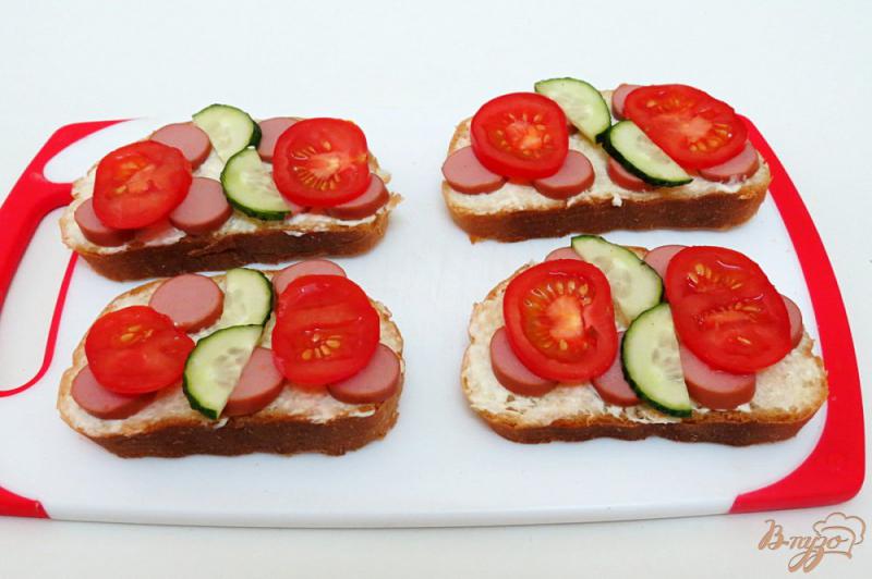 Фото приготовление рецепта: Горячие бутерброды с сосиской помидором и огурцом шаг №5