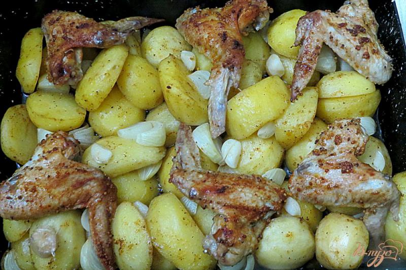 Фото приготовление рецепта: Куриные крылышки запеченные с картофелем шаг №10