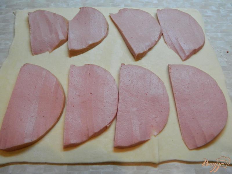 Фото приготовление рецепта: Закуска из слоеного теста колбасы и сыра шаг №2
