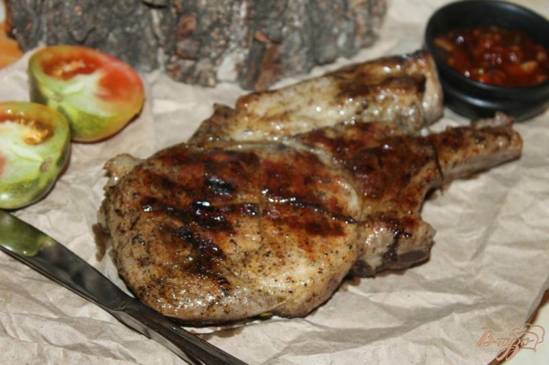 Фото приготовление рецепта: Свиной стейк на косточке маринованный в ароматном масле с чесноком шаг №6