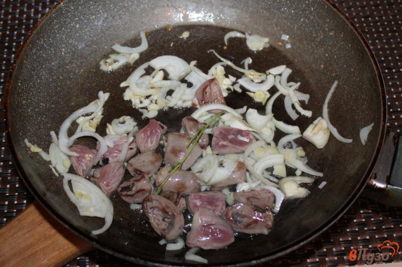 Фото приготовление рецепта: Рис с куриными сердечками и луком шаг №4
