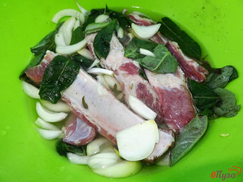 Фото приготовление рецепта: Свиные ребра в маринаде с мятой и луком шаг №7