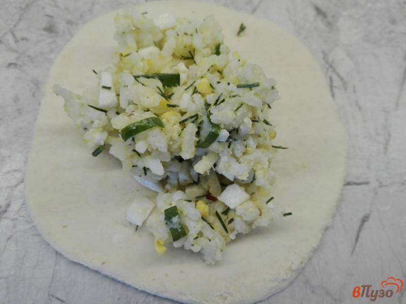 Фото приготовление рецепта: Пирожки из слоеного теста с рисом, яйцами и зеленью шаг №5