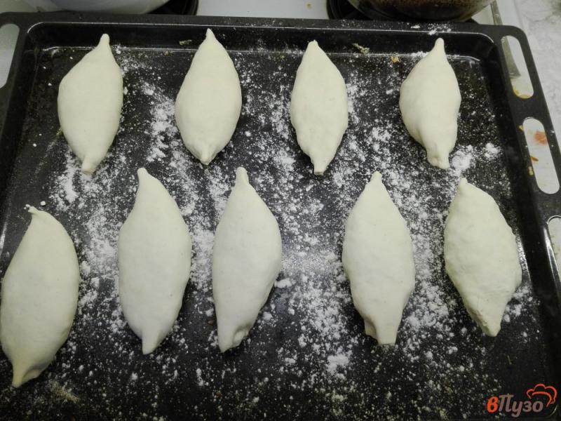 Фото приготовление рецепта: Пирожки из слоеного теста с рисом, яйцами и зеленью шаг №7