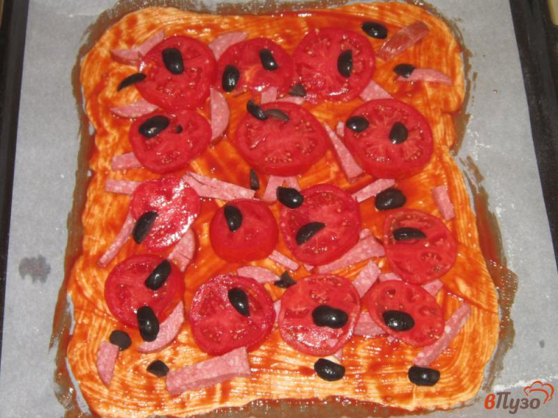 Фото приготовление рецепта: Пицца на слоеном тесте с сыром, колбасой и маслинами шаг №4