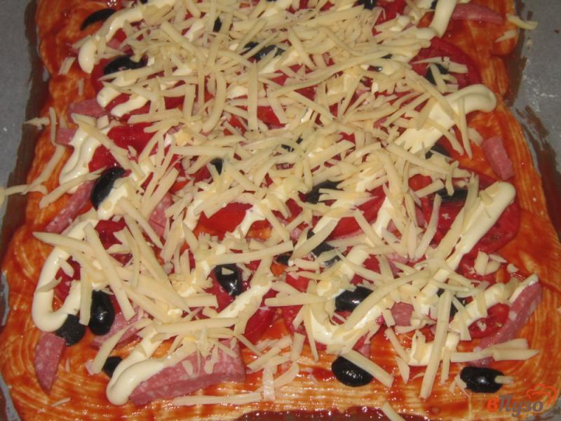 Фото приготовление рецепта: Пицца на слоеном тесте с сыром, колбасой и маслинами шаг №5