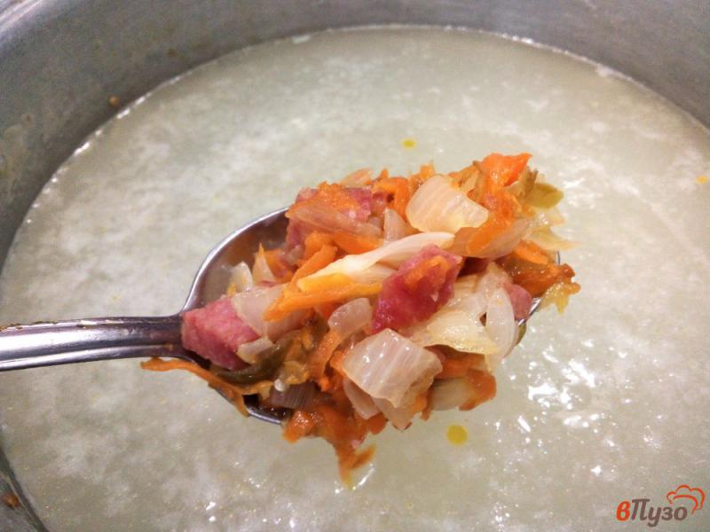 Фото приготовление рецепта: Пшенный суп с варено-копченой колбасой, соленым огурцом и оливками шаг №7
