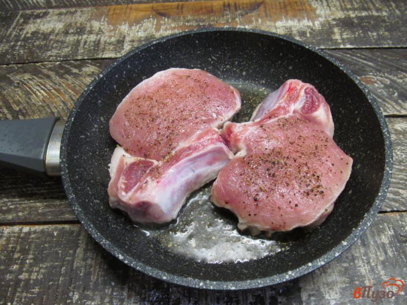 Фото приготовление рецепта: Свиные стейки на косточке с гарниром из помидора и грибов шаг №2