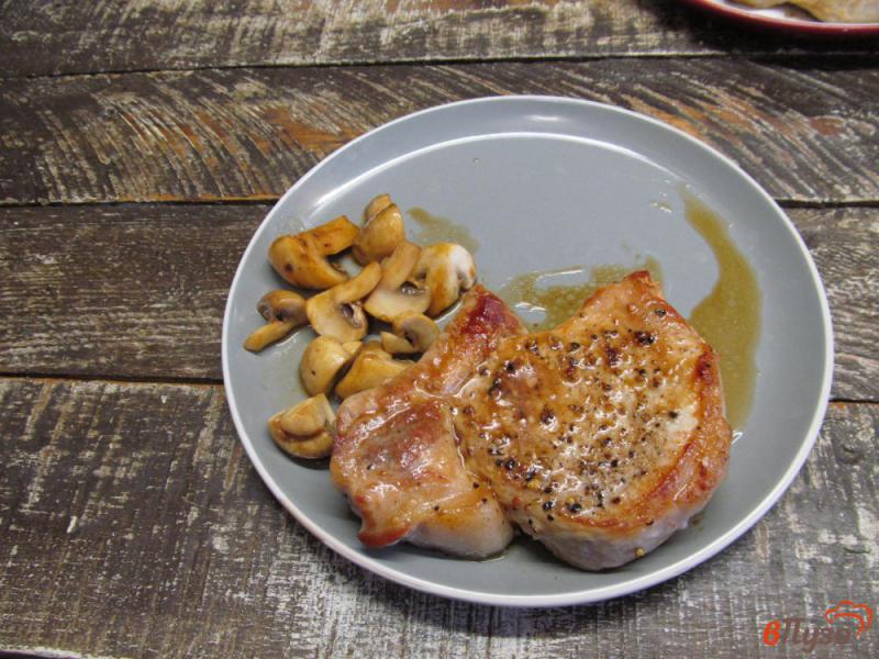 Фото приготовление рецепта: Свиные стейки на косточке с гарниром из помидора и грибов шаг №5