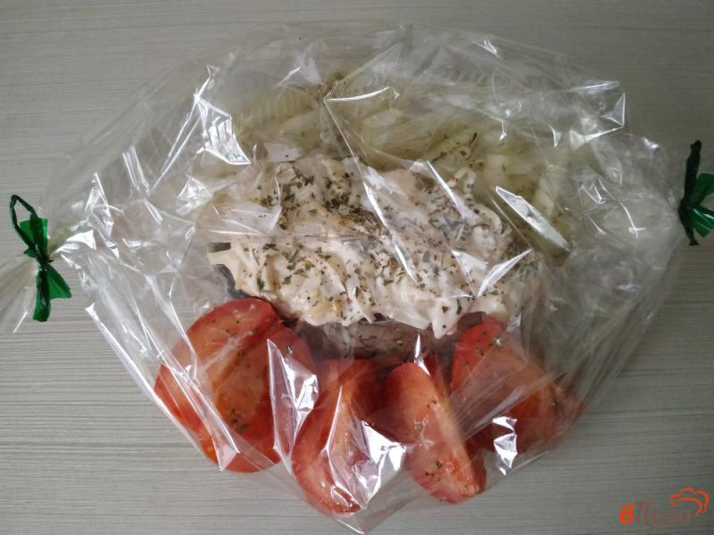 Фото приготовление рецепта: Запечённый толстолобик под сырной корочкой с помидорами и луком шаг №6