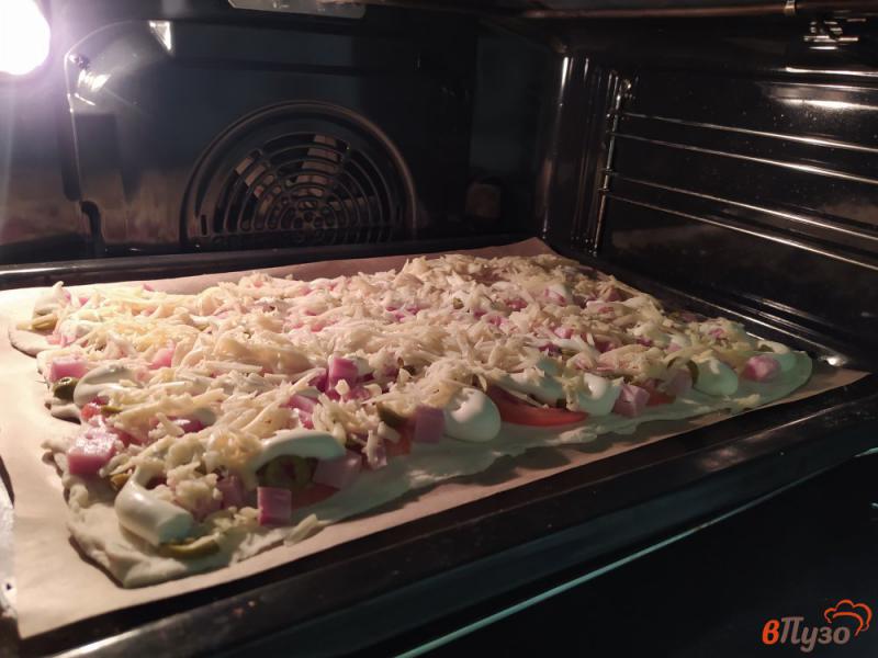 Фото приготовление рецепта: Пицца на слоеном тесте с ветчиной и помидорами шаг №7