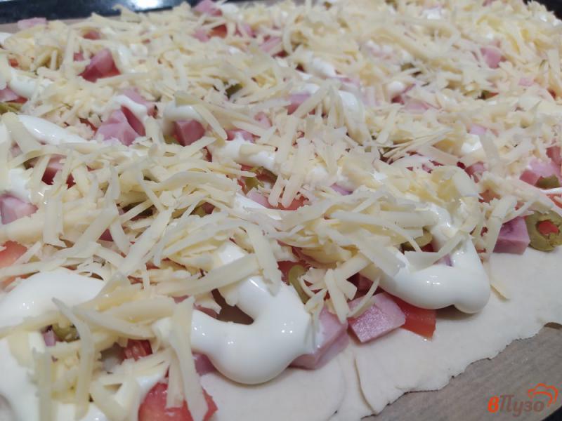 Фото приготовление рецепта: Пицца на слоеном тесте с ветчиной и помидорами шаг №6