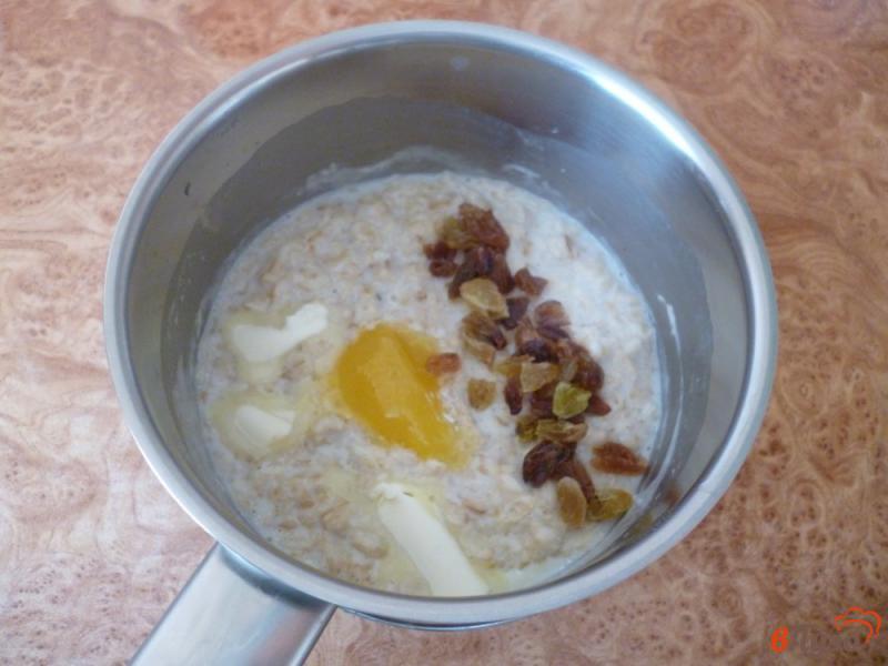 Фото приготовление рецепта: Овсяная каша на молоке с изюмом и орехами шаг №3