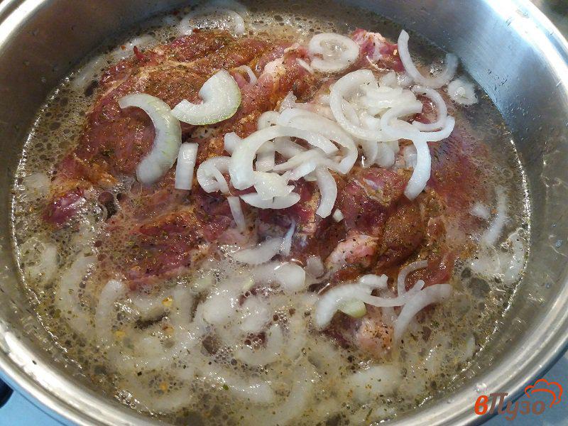 Фото приготовление рецепта: Стейк из свинины маринованные в специях с луком и лимонным соком шаг №7