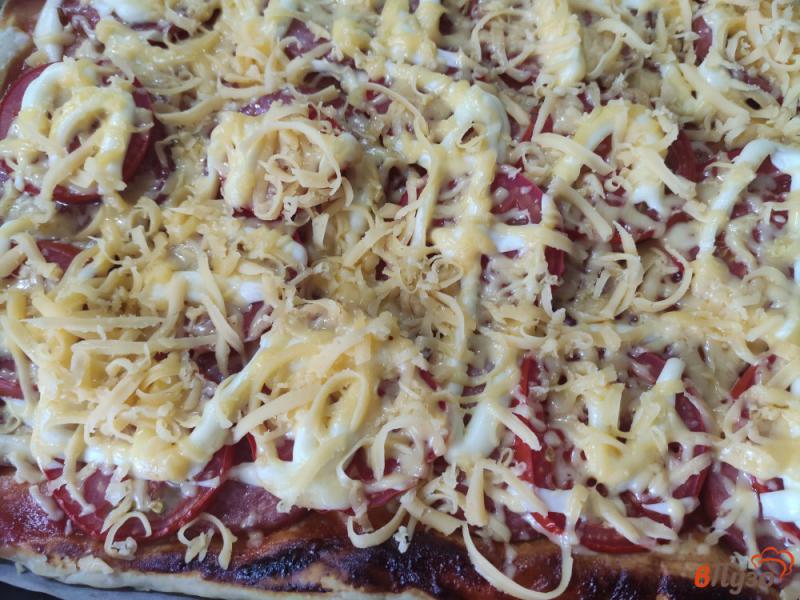 Фото приготовление рецепта: Пицца на слоёном тесте с колбасой и помидорами шаг №7