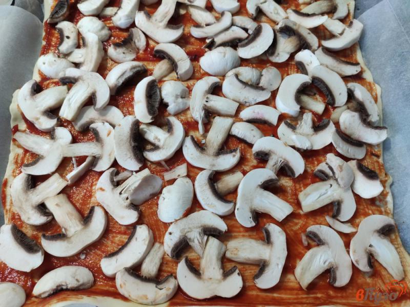 Фото приготовление рецепта: Пицца на слоеном тесте с шампиньонами помидорами и сосисками шаг №3