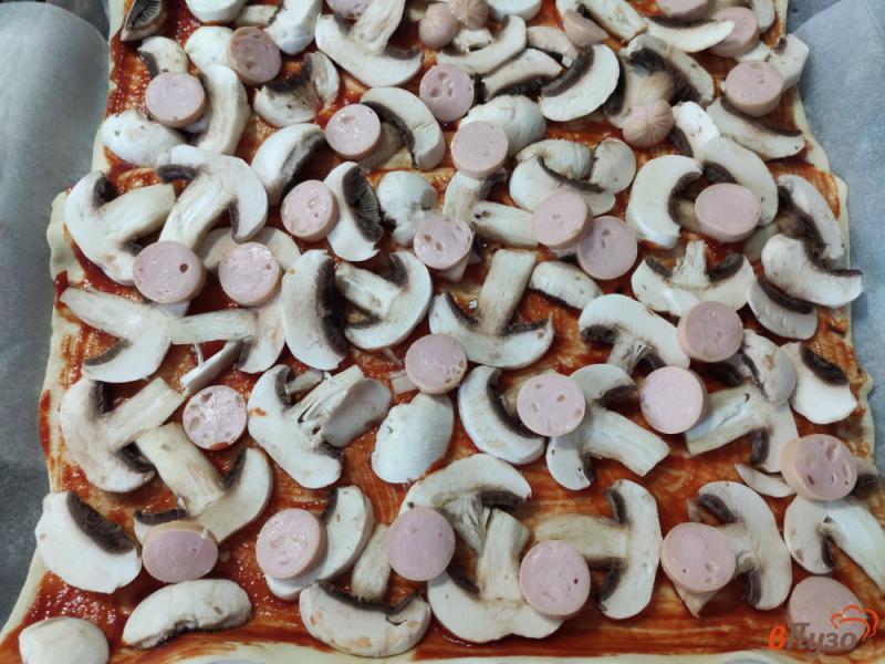 Фото приготовление рецепта: Пицца на слоеном тесте с шампиньонами помидорами и сосисками шаг №4