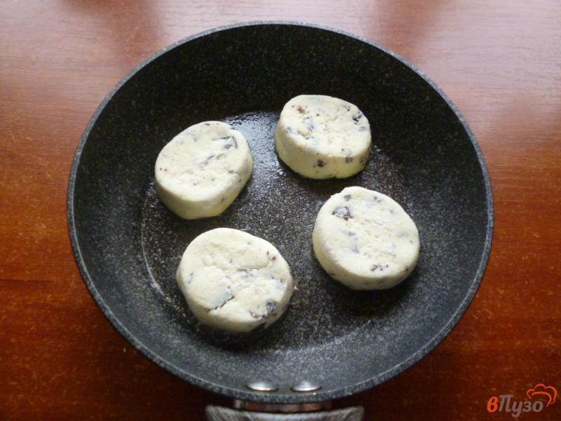Фото приготовление рецепта: Сырники с изюмом и шоколадом шаг №7