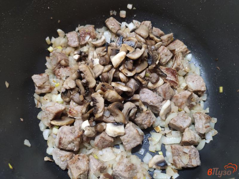 Фото приготовление рецепта: Свинина тушёная с шампиньонами в сметане с кетчупом шаг №6