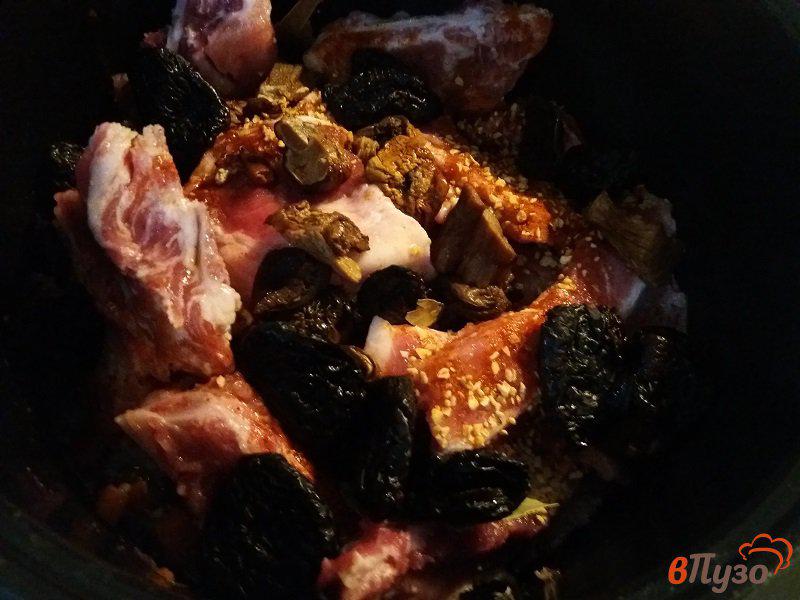 Фото приготовление рецепта: Томлёные свиные рёбрышки с черносливом и белыми грибами шаг №9