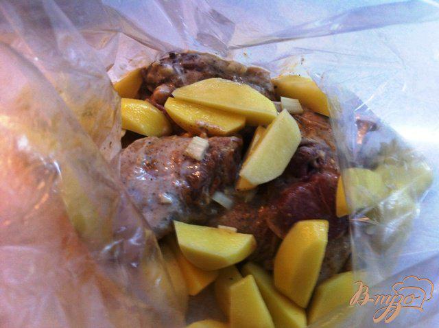 Фото приготовление рецепта: Куриные бедрышки с картофелем, запеченные в пакете шаг №7
