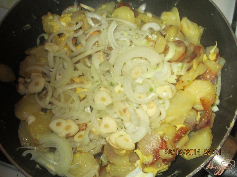Фото приготовление рецепта: Жареная картошка с яйцом, луком и чесноком шаг №4