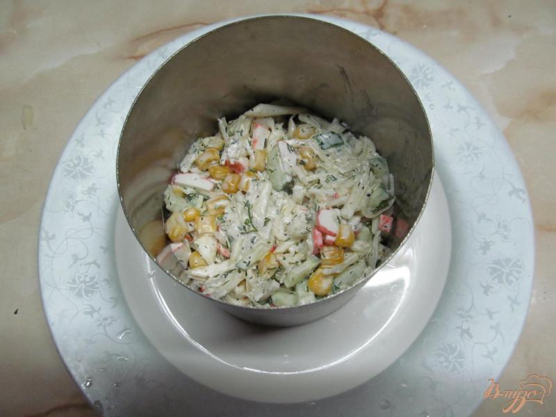Фото приготовление рецепта: Салат из капусты, огурца, кукурузы и крабовых палочек шаг №7
