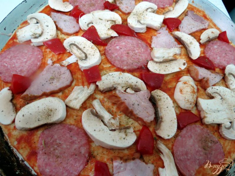 Фото приготовление рецепта: Пицца с салями,  ветчиной и грибами шаг №6