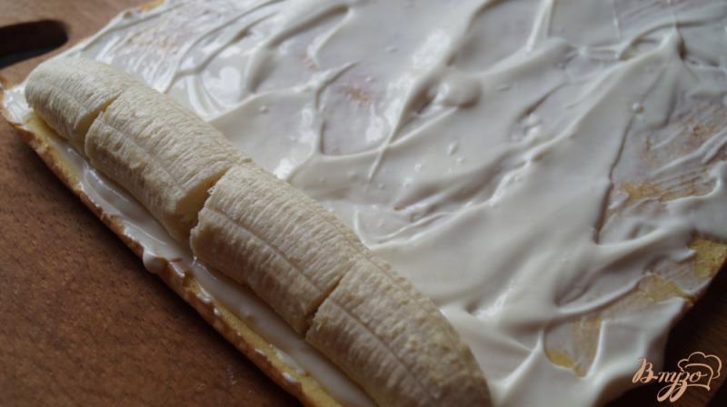 Фото приготовление рецепта: Бисквитный рулет со сметанным кремом и бананом шаг №10